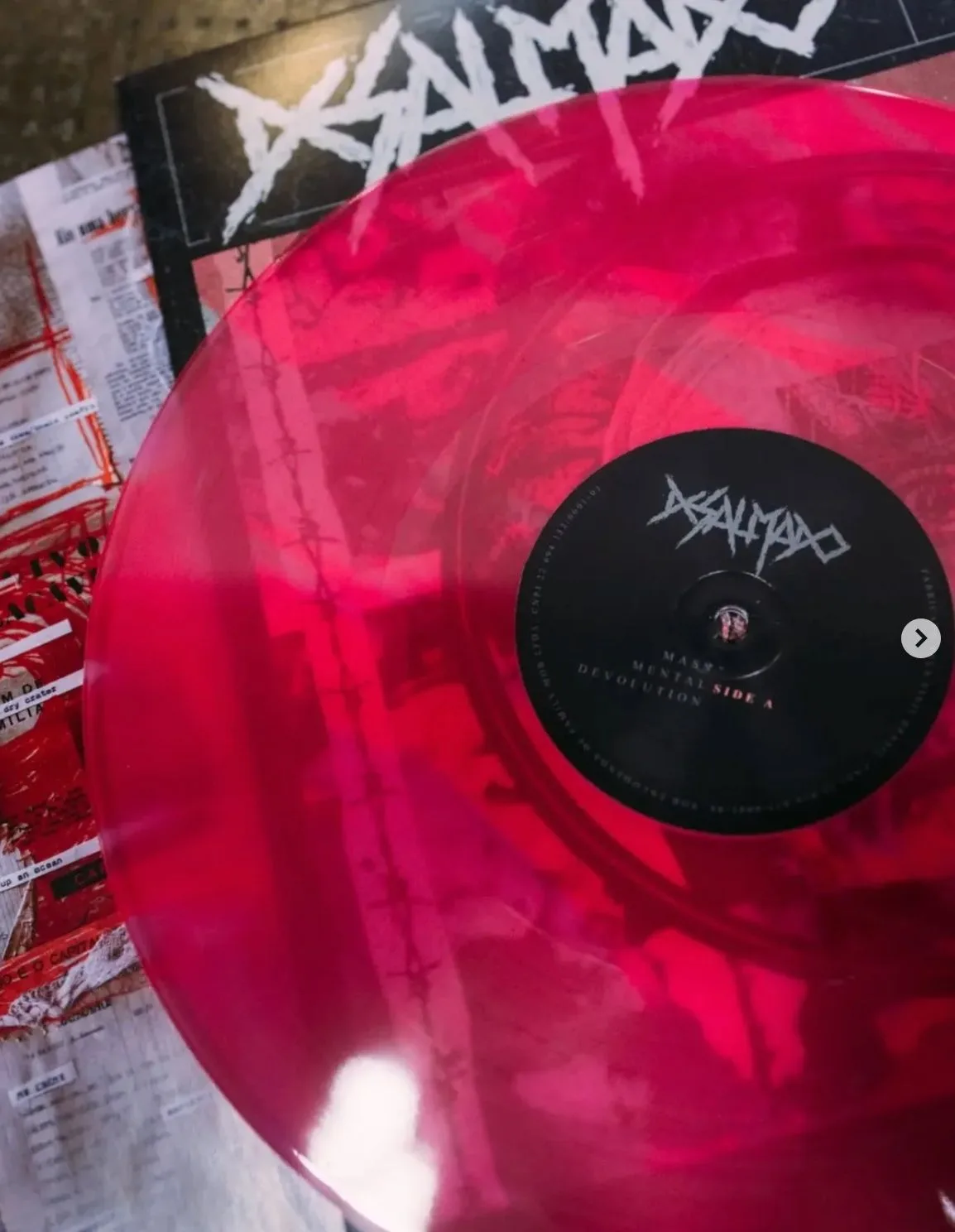 Foto de um vinil rosa/vermelho, disco Mas Mental Devolution